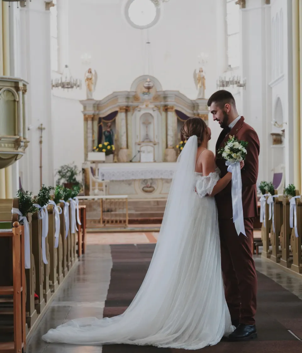 Bruidspaar in het middenpad van een witte kerk